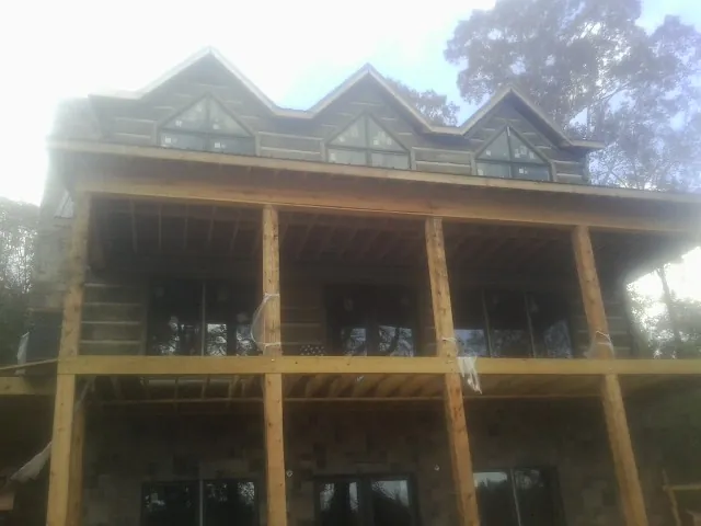 Dormers and porch framing on a large log home under construction — Roof Coating work by our crew in Chattahoochee